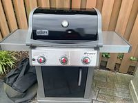 Front view of the Weber Spirit gas grill with three control knobs and closed lid, showing Weber badge on the front.