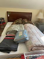 Full bed frame assembled with bedding and blankets on top for display.