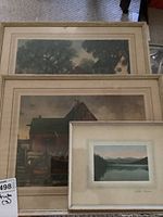 Three stacked framed prints showing two larger landscape/architectural prints and one smaller landscape print signed Lake Louise.