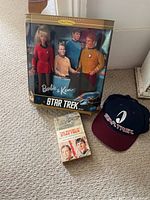 Barbie and Ken Star Trek dolls in original packaging with book and cap on carpeted floor