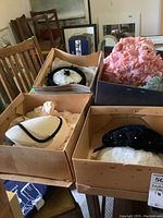 Six vintage ladies hats arranged in open boxes showing variety of colors and styles, some with netting.
