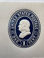 Close-up of embossed blue one-cent stamp showing profile of Benjamin Franklin.