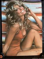 Full view of the 1976 Farrah Fawcett poster showing her seated in a brown swimsuit on a striped background, smiling with visible wear.