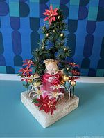 Full view of the Mid Century Angel Christmas display showing angel figure, floral arrangement, and textured base.