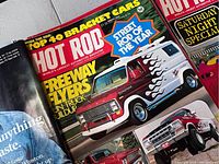 Close-up of Hot Rod magazine cover featuring a customized van with red and white paint and flame decals, highlighting automotive content.