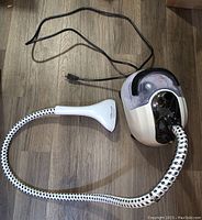 Full view of the garment steamer unit with flexible hose and handheld steam head.