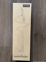 Box showing illustration of the Joyful Holder with flexible arm and clamp base