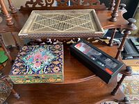 Overall view of the decorative tray, floral box, and Toscana cups box arranged on a wooden shelf.