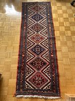 Full view of the Persian runner on parquet floor showing overall pattern and dimensions