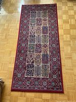 Full view of the rectangular carpet runner laid on wooden floor, showing overall pattern and condition