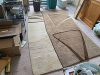 Photo of the 5 x 8 foot rug laid out on the floor, showing full abstract geometric pattern with beige and brown colors