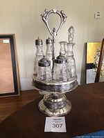 Full view of the antique silverplate and etched glass condiment carousel with multiple containers including salt and pepper shakers and jars with lids