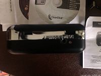 Close-up image showing the ClearClick Cassette2USB Converter device and documents including a software CD and manual.