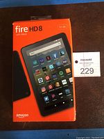 Original orange retail packaging for Amazon Fire HD8 tablet with Alexa, showing front of box with device and app icons.
