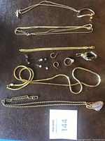 Full overview of all jewelry items including necklaces, bracelets, rings, and earrings on brown surface.