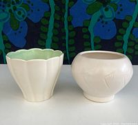 Front view of both McCoy and Red Wing glazed pots, showing their shapes and colors