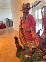 Full-body view of painted bronze statue on hardwood floor with surrounding furniture