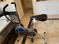 Side view of the Weslo stationary bike showing black seat, pedals, and silver-blue frame explaining size and condition.