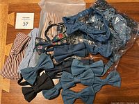 Top view of assorted denim and patterned hair bands and denim bow ties, laid out on a wooden surface, with some hair bands in clear packaging.