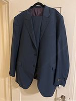 Blue Jack Victor men's suit jacket hanging on a hanger, showing front side and part of the lining inside.