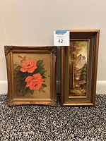 View of two framed paintings side by side showing floral still life with coral flowers and MCM landscape painting with mountain scene.