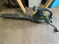 Electric leaf blower lying on floor showing full length and nozzle