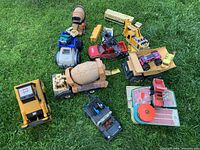 Overview of various construction and toy vehicles on grass