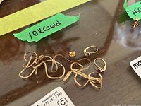 Overview of broken chain, earrings, loose back, and green “10K gold” label