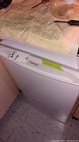 Photo of the closed fridge with measurement label on top and visible Denby logo.