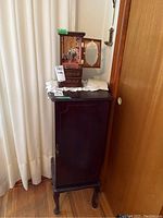 Full view of standing jewelry cabinet with tabletop cabinet on top, showing dark wood finish and overall size comparison.