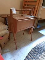 Wood stand sewing box viewed from an angle showing shape and handle