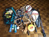 Full overview of the sports lot showing rackets, gloves, frisbee, walking sticks and balls next to the sports bag