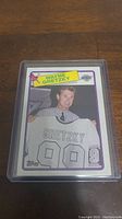 Photo of 1988-89 Topps Wayne Gretzky hockey card showing player holding his jersey with name and number 99.