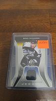 Front of Brad Richards jersey trading card in protective case showing player image and jersey fabric swatch.