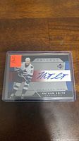 Upper Deck Trilogy hockey card with Nathan Smith in white Vancouver Canucks uniform. Blue ink autograph on card front.