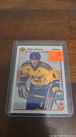 Rookie hockey card of Niklas Lidstrom in yellow Sweden jersey, encased in protective plastic with orange RC sticker