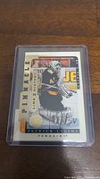 Photo of an autographed Patrick Lalime hockey card in protective plastic holder showing player in Penguins uniform and his signature.