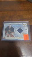 Hockey card showing Roman Turek in goalie uniform with a piece of his game-worn jersey embedded. Card is in a clear plastic holder and has a price tag sticker