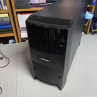 Front view of black Bose subwoofer speaker showing vented grills and Bose logo on front panel.