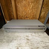 Front view of the silver Magnavox VCR DVD combo player showing VHS slot and control panel