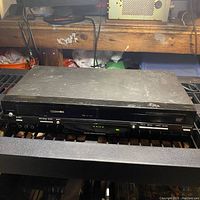 Front view of Toshiba DS-KV260KU DVD VCR combo player with visible wear and scratches, showing front controls and slot.