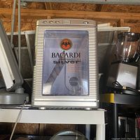 Front view of Bacardi Silver branded mini refrigerator cooler on a shelf.
