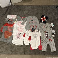 All items laid out on a dark carpet showing variety of kids holiday clothing in new condition