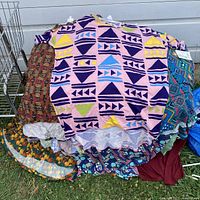 Pile of folded colorful LuLaRoe clothing laid on ground with various patterns visible, including geometric and floral prints.