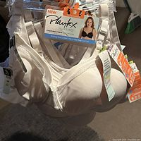 Photo of several Playtex nursing bras hanging on plastic hangers showing product labels and sizes 34B/C and 34D/DD