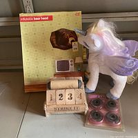 Photo of inflatable bear head box, Furreal unicorn plush, Strike It game and Labeda hockey wheels