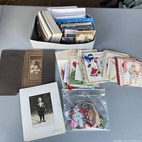 Overview photo showing box of various ephemera and mounted photographs on table