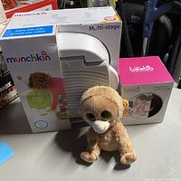 Overview photo showing Munchkin potty chair box, Beebo bottle holder box, and Ty Beanie Boo Monkey plush toy in front.