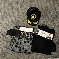Photo of the Nightmare Before Christmas pants folded with packaging label and the vintage black hat with yellow embroidery.