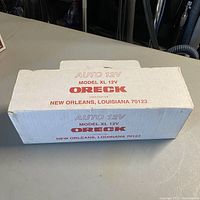 Original box labeled 'Auto 12V Model XL Oreck' in white and red text with address in New Orleans, Louisiana.